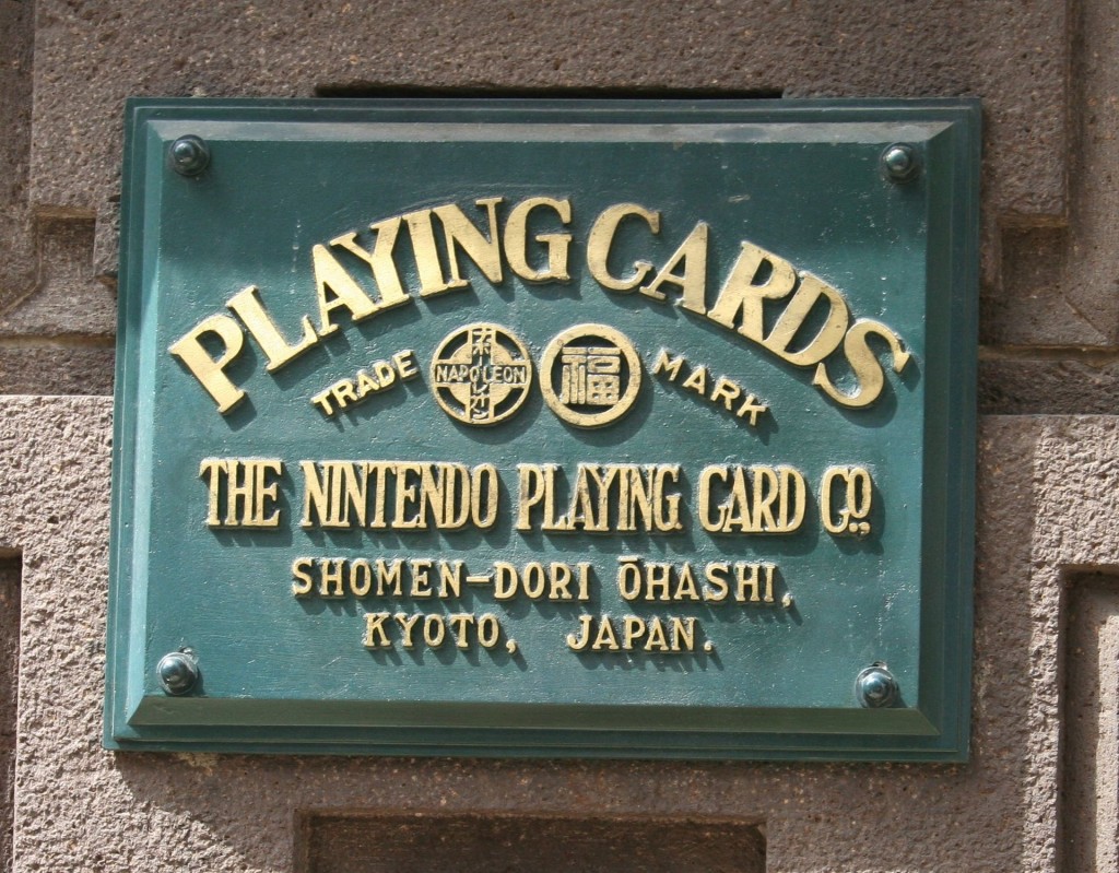 Plaque de la société à l'emplacement des anciens bureaux principaux de cartes à jouer de Nintendo, à Kyoto, au Japon, devenu plus tard la célèbre compagnie de jeux vidéos. Dans le cercle de gauche est inscrit « NAPOLEON » en caractères latin et l'équivalent en katakana (ナポレオン). Dans le cercle de droite, le traditionnel caractère chinois de la bonne fortune.