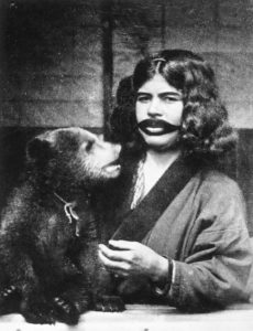 Une Aïnou à la bouche tatouée, tenant un ourson sauvage (1922).